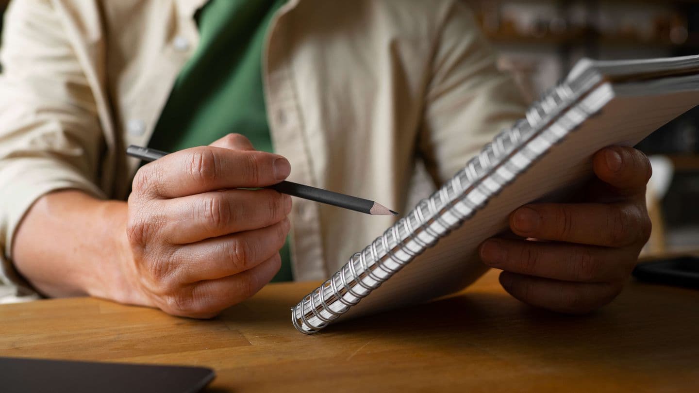 man writing notepad
